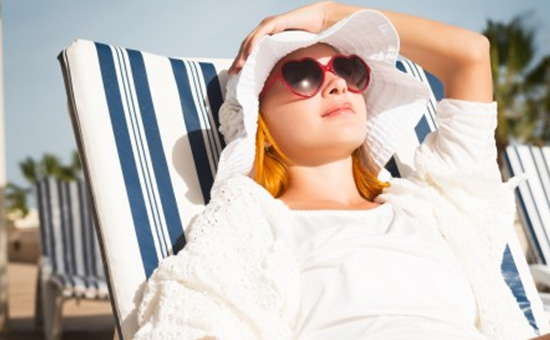 Woman on beach wearing trendy sunglasses prescribed by optician