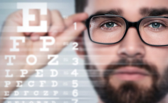 Man trying on prescription glasses during eye consult  with local ophthalmologist